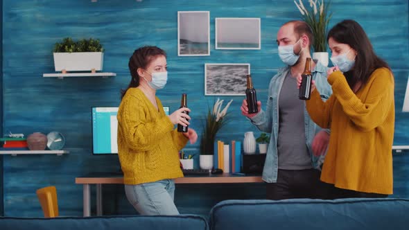 Group of Friends Toasting with Bottles of Beer Wearing Protective Mask