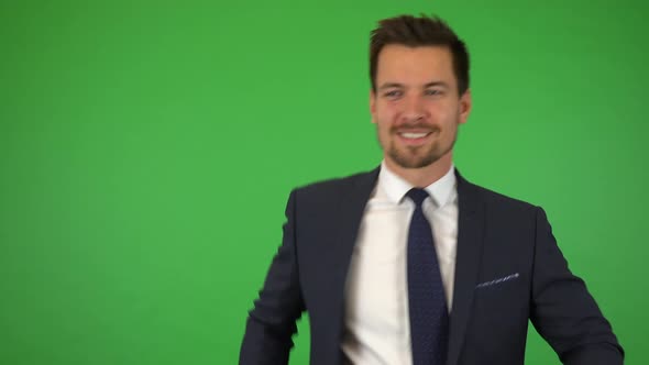 A Young Handsome Businessman Dances and Smiles at the Camera - Green Screen Studio