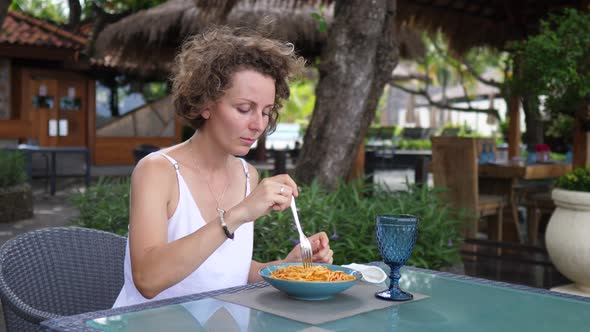 Caucasian Woman Takes Off Her Face Mask To Eat Pasta in Outdoor Restaurant