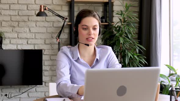 Young call operator businesswoman wears headset customer service manager looking and speaking to web