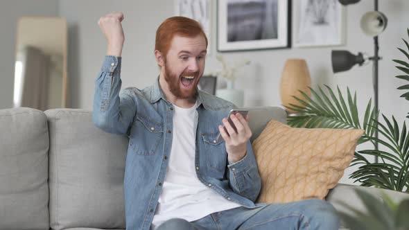 Excited Man Celebrating Success on Smartphone