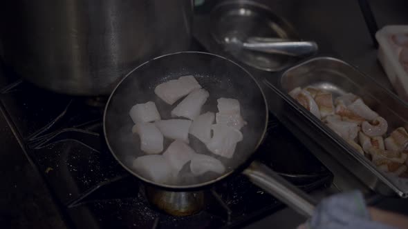 Close View of Pieces of White Fish Being Flambed in Frying Pan