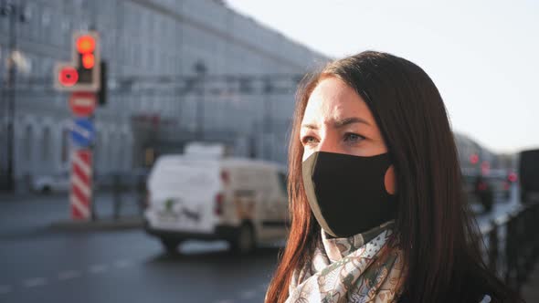 Young Woman in a Medical Mask for Protection From the Epidemic on the Street in the City