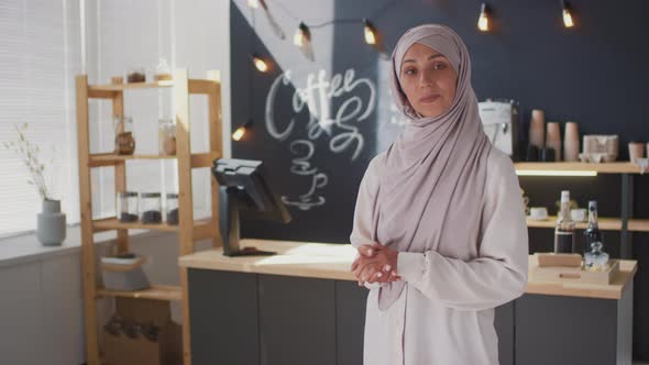 Portrait Of Happy Muslim Saleswoman At Cafe