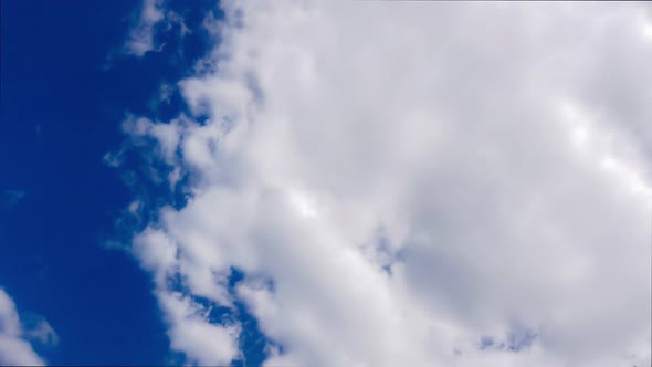 Timelapse Movement of White Cumulus Clouds on Bright Blue Sky 