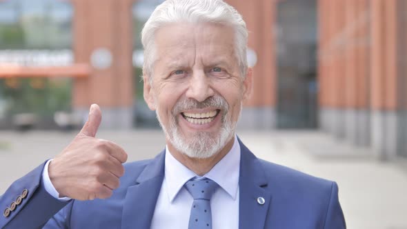 Outdoor Portrait of Thumbs Up by Old Businessman