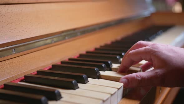 One Hand Playing Some Chords On A Vintage Piano