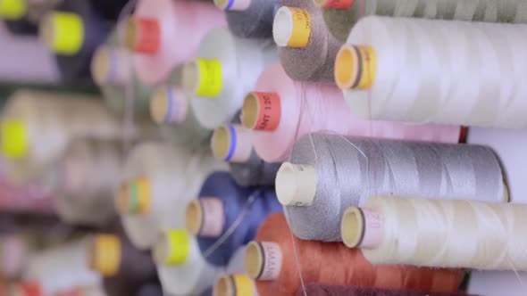 Close up of a spools for sewing at a wall.