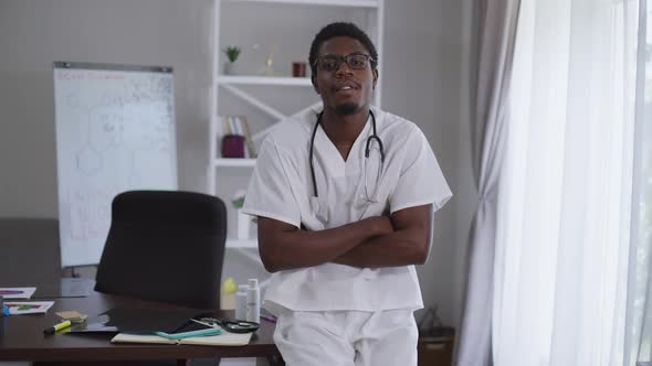 Portrait of Genius African American Scientist in Eyeglasses Crossing Hands Looking at Camera