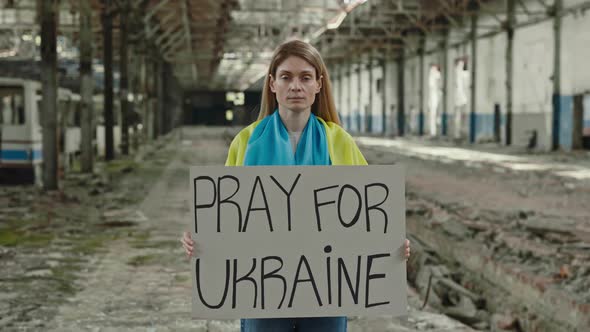 Portrait of Female Holding Anti War Banner at Ruined Factory