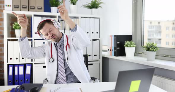 Young Male Doctor in Headphones is Dancing at Workplace in Clinic  Movie