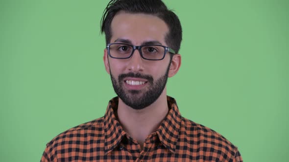 Face of Happy Young Bearded Persian Hipster Man Talking