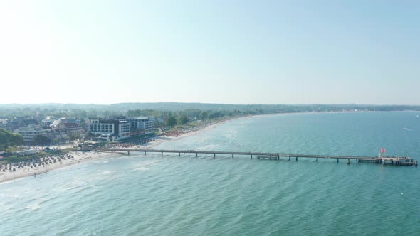 Aerial Drone View Flying Above Baltic Sea Pier Beach in Scharbeutz Germany Summer Sunny Day Circle