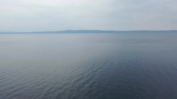 Aerial video of calming water of the Adriatic Sea during a warm sunny morning with a blue cloudless