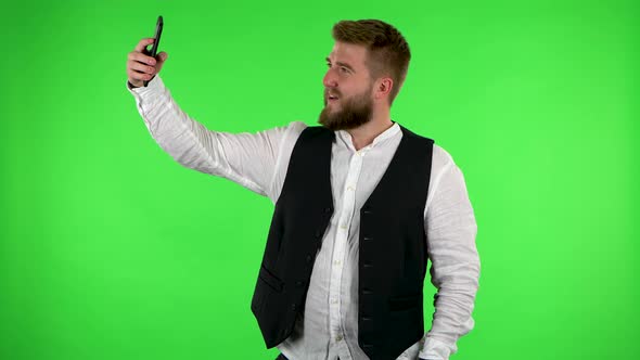 Man Makes Selfie on Mobile Phone Then Looking Photos on Green Screen