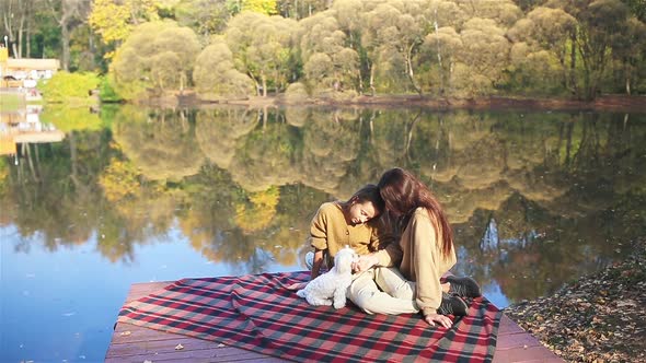 Mother and Little Kid at Autumn Warm Day Near Lake