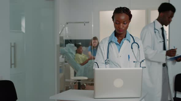 Woman Doctor with Stethoscope Working with Modern Laptop