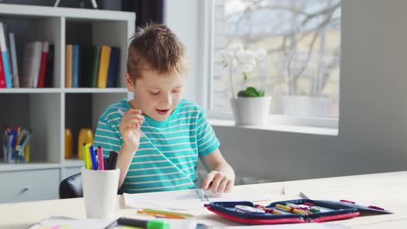 Boy is Doing  Homework at the Table. Cute Child is Learning at Home.