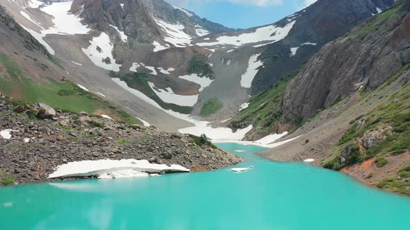 Big Snowy Mountains with Glacier Above Mountain Lake. Aerial View 