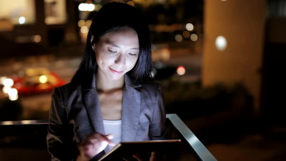 Business woman using tablet computer at night 