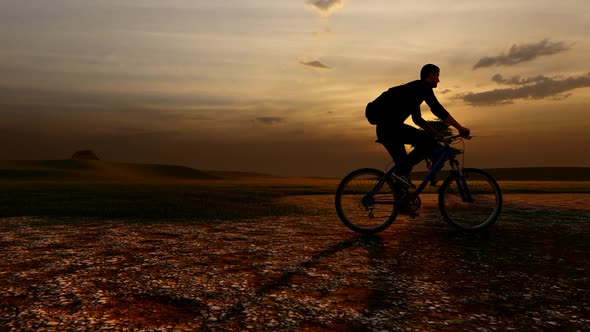 Young Man on Bicycle with Sunset View