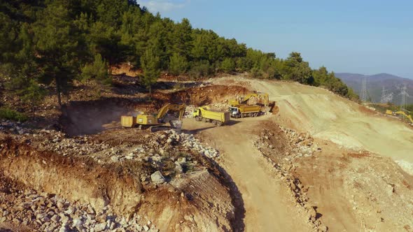 Excavators and Dump Trucks Working at Mountains Mining Quarry