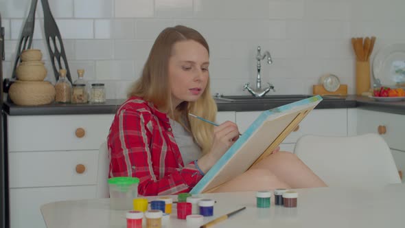 Creative Lovely Middle Aged Woman Painting Picture on Canvas in Kitchen