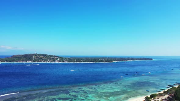 Aerial top view panorama of idyllic tourist beach trip by blue ocean and clean sandy background of a