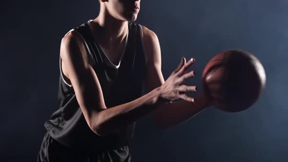 A Young Basketball Player is Practicing a Serve with the Ball