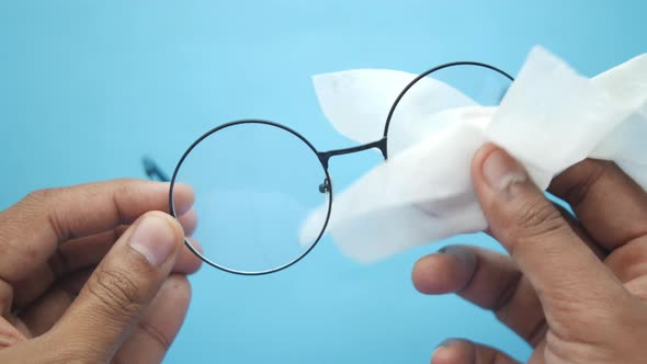 Close Up of Man Hand Cleaning Eyeglass with Tissue