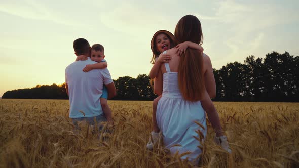 Slow Motion Parents Walking in Field with Kids in Arms