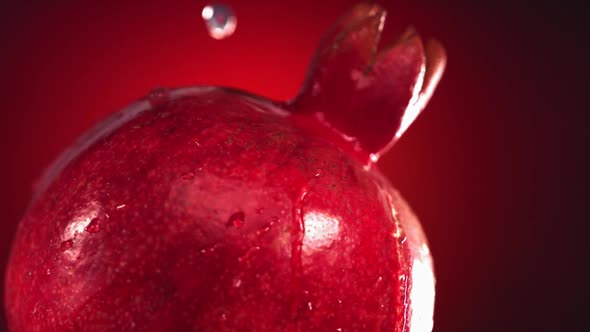 Super Slow Motion Water Drips on Rotating Pomegranate