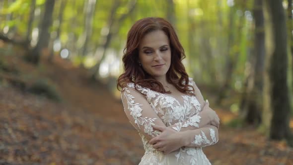 Bride in Wedding Dress Stay in the Forest Park. Happy. Woman in Love