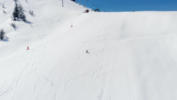 Aerial: one person skiing on snow in Sestriere ski resort, Turin Italy