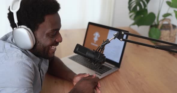 Young african man doing podcast using computer laptop at home - Technology trend concept