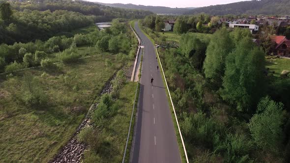 man roller skating on empty road, sunset, cinematic aerial shot