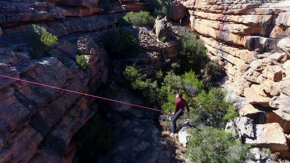 Male highliner lying on a rope over rocky mountains 4k