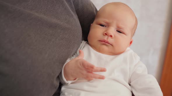 the Baby Lies in His Mother's Arms and Falls Asleep