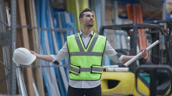 Satisfied Middle Eastern Contractor Admiring Variety of Goods in Industrial Warehouse
