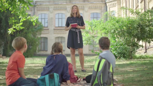 Outdoor Lesson for Middle School Students. Wide Shot of Confident Positive Caucasian Woman Talking