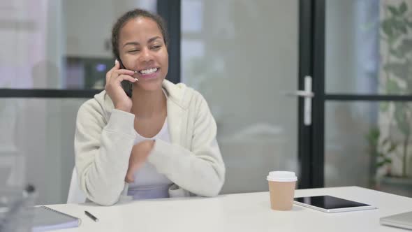 African Woman Talking on Smartphone in Office