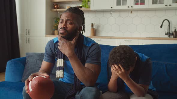 Black Father and Boy Watching American Football on Tv Disappointed By Team Loss