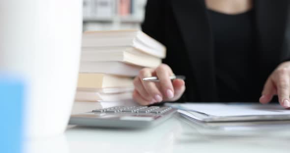 Businesswoman or Accountant Holding a Pen Working on Calculator to Calculate