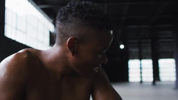 Portrait of african american man resting after battling ropes in an empty urban building