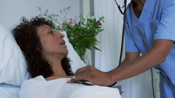 Close-up of African american female doctor examining female patient in the ward at hospital