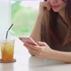 Young woman with drinks using mobile phone and relaxing in cafe - VideoHive Item for Sale