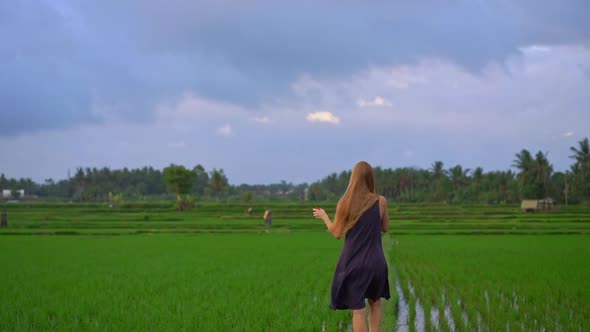 Slowmotion Shot of a Young Woman with a Kite Walking Through a Big Beautiful Rice Field