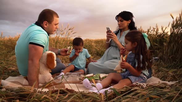 A Family Picnic on Nature in a Summer Field at Sunset in Slowmo