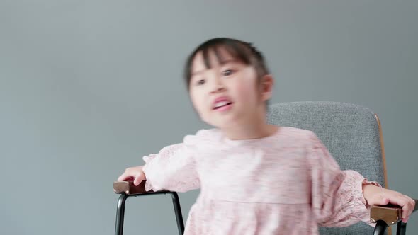 Child watching television and dancing sitting in armchair. Happy with what you are watching.