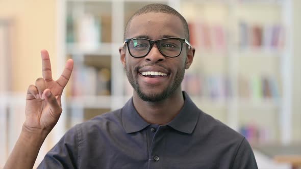 Portrait of Young African Man Showing Victory Sign with Hand